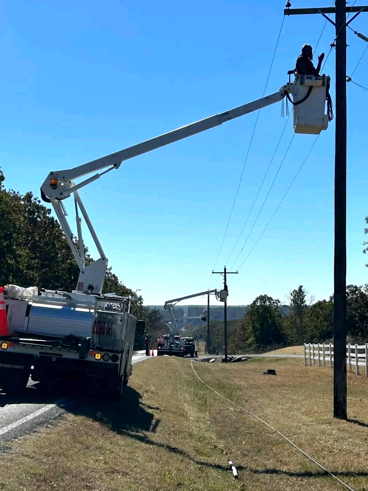 Bucket truck servicing pole at dusk