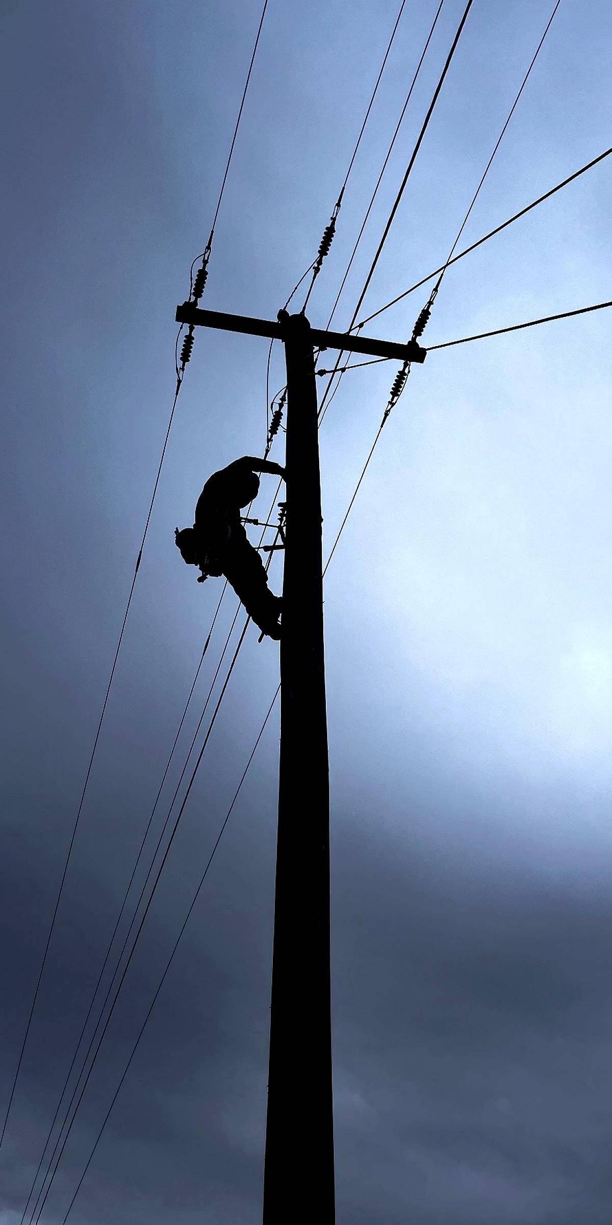 Lineman climbing and working at a pole