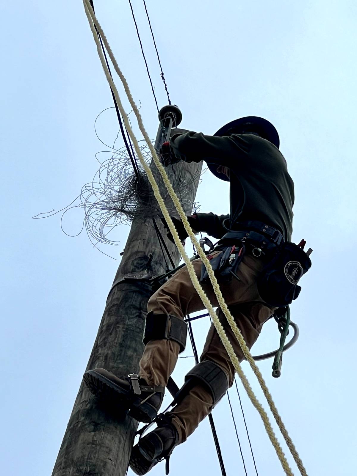 Climber on a pole in a right‑of‑way